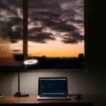 turned on laptop on desk near window